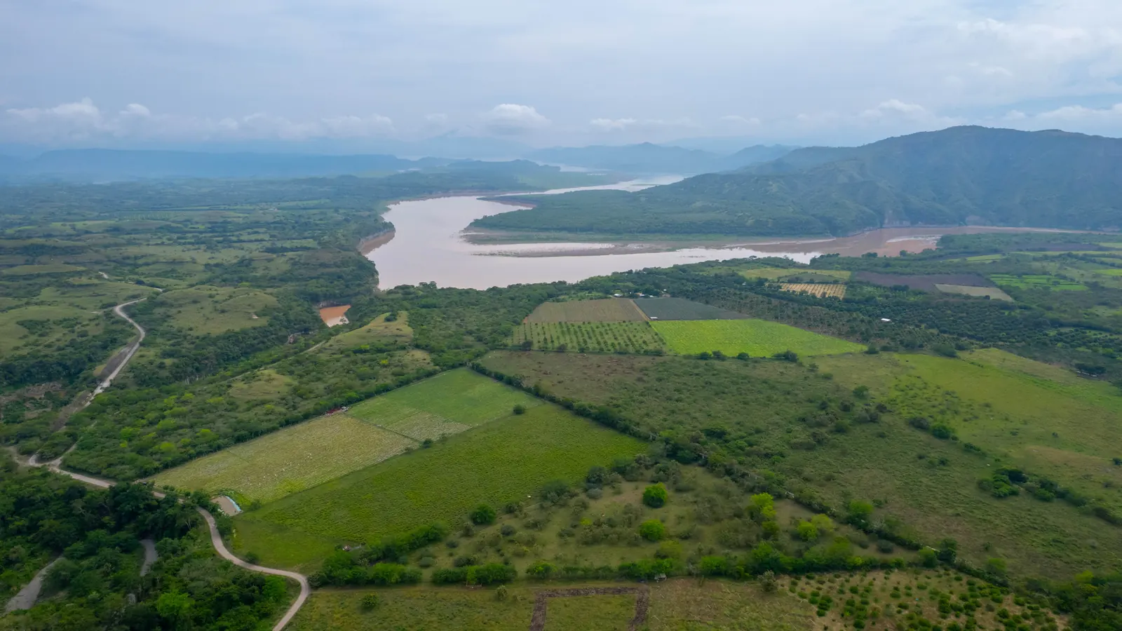 Panorama de cultivos, río y montañas fotografiado por SiembraCo